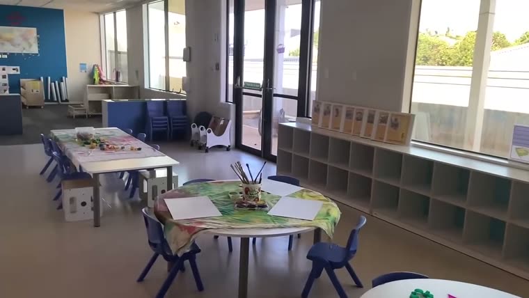 A light-filled classroom with low tables and windows along one wall